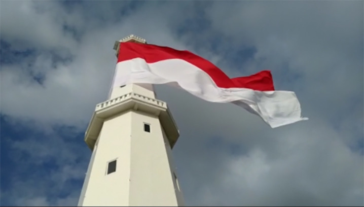 Pengibaran bendera merah putih raksasa di puncak menara suar di perbatasan Indonesia dan Timor Leste. FOTO: DITJEN HUBLA