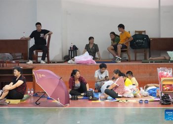 Orang-orang beristirahat di tempat penampungan di Xiangshan, Provinsi Zhejiang Cina timur, Rabu (14/9). FOTO: XINHUA